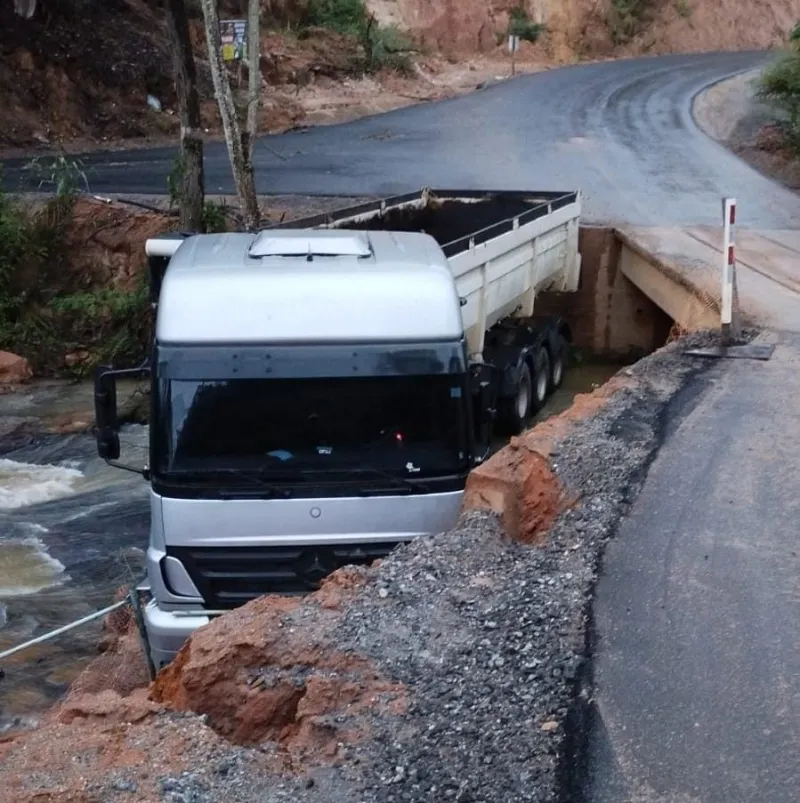 Acidente em estrada recém-asfaltada termina com caminhão dentro de rio em Colatina